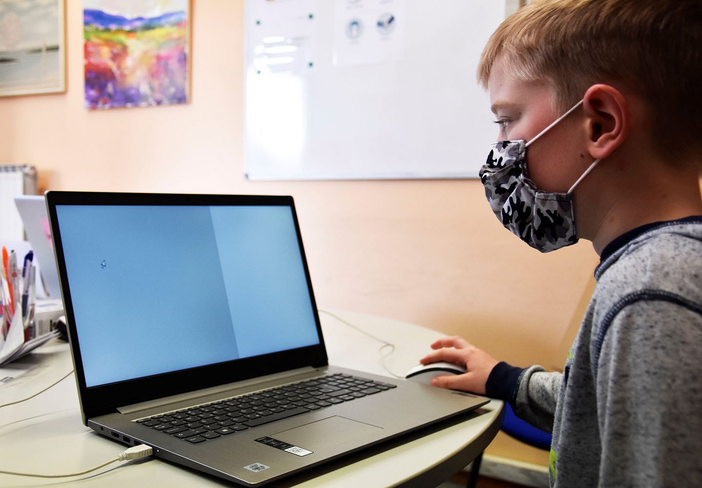 Osnovnošolec ima usmerjen pogled na zaslon računalnika